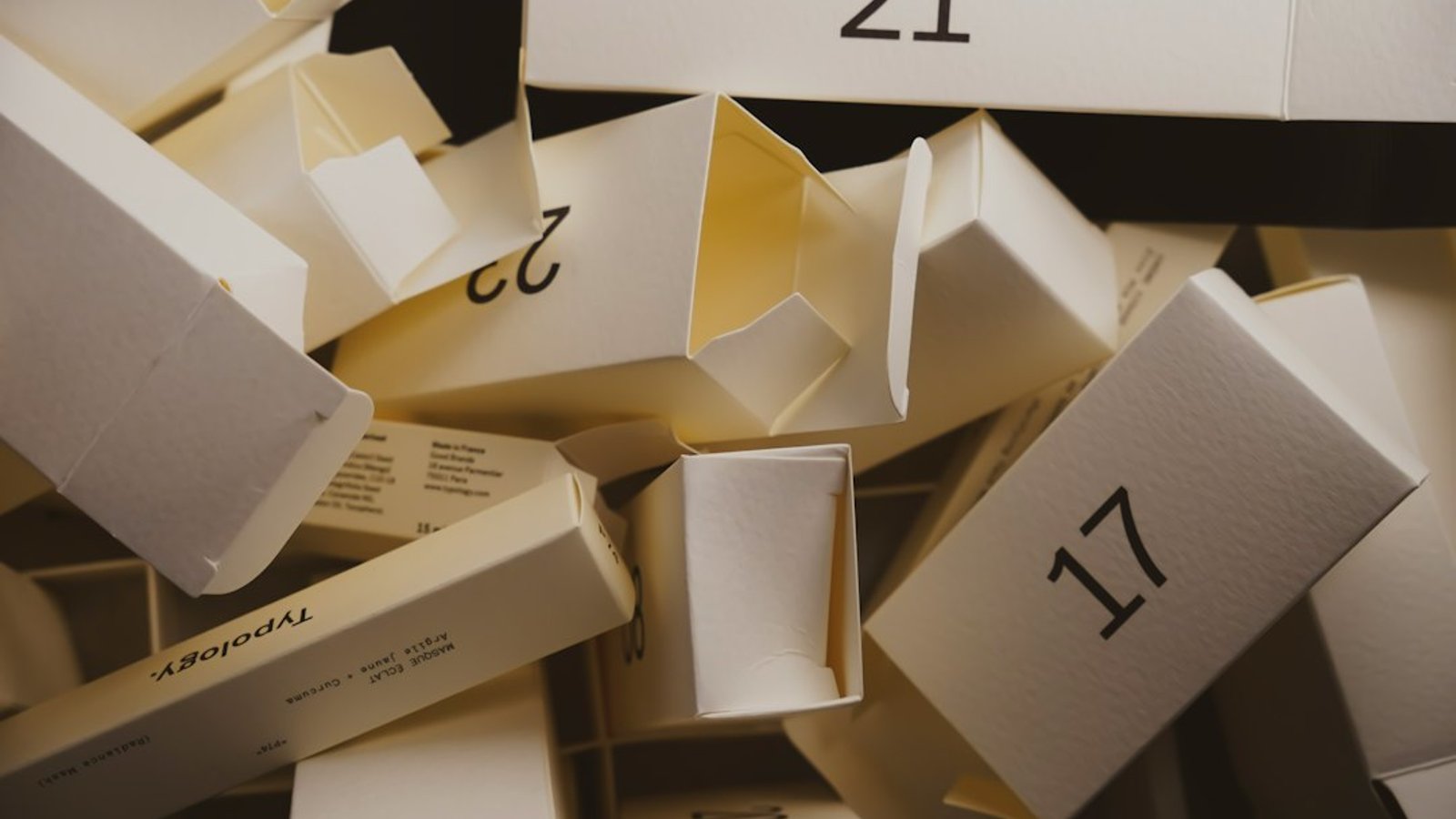 Calendrier de l'avent homme ouvert sur une table en bois avec flacons de parfum et soins alignés