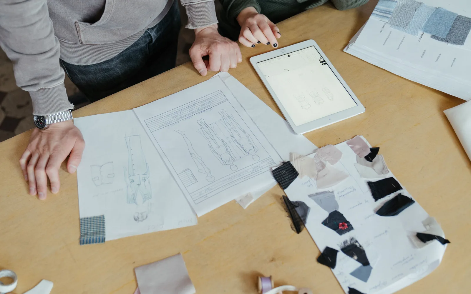 Patrons, croquis et échantillons de tissu sur une table d’atelier